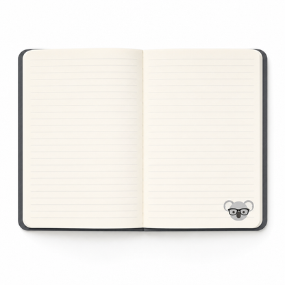 The softcover notebook open showing ruled ivory pages